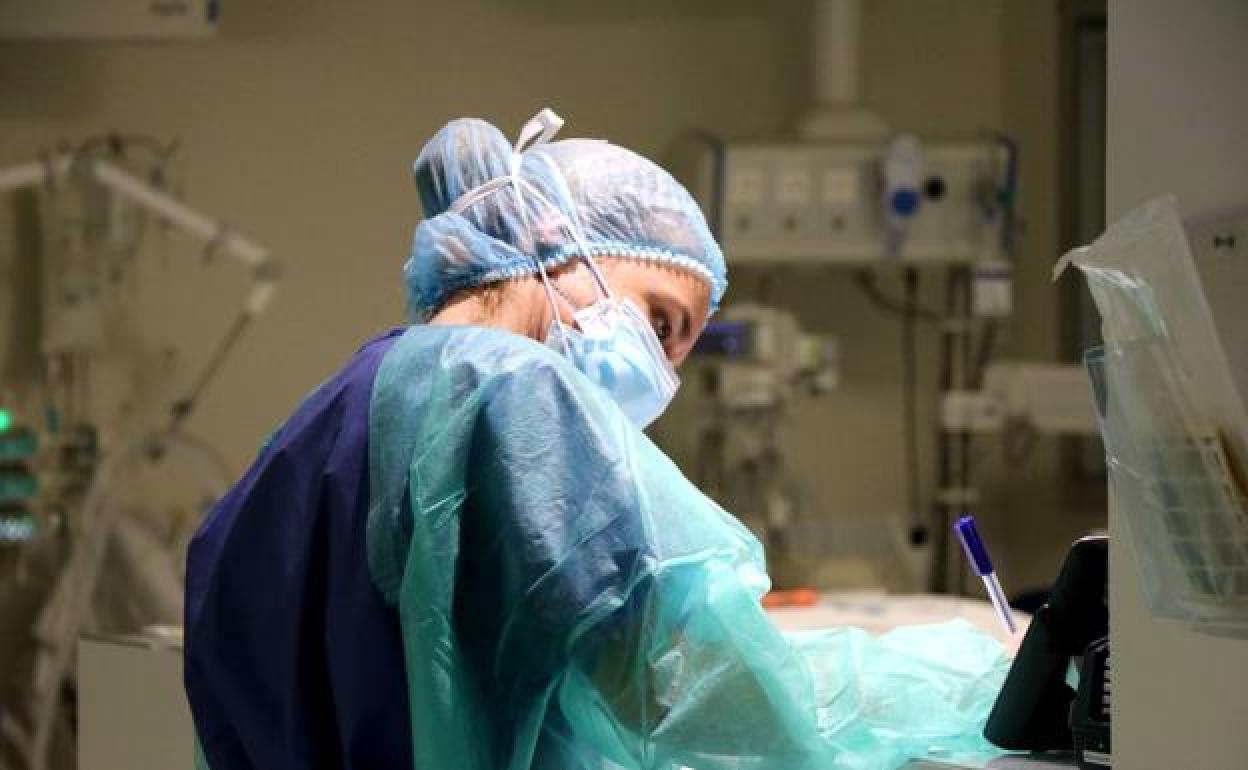 Una sanitaria atiende en el mostrador del hospital.