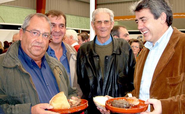 XII Feria de la Cecina de Chivo en Vegacervera (León). En la imagen, Miguel Martínez (D), secretario provincial del PSOE, confraterniza con Cipriano Elías (I), vicepresidente popular de la Diputación de León