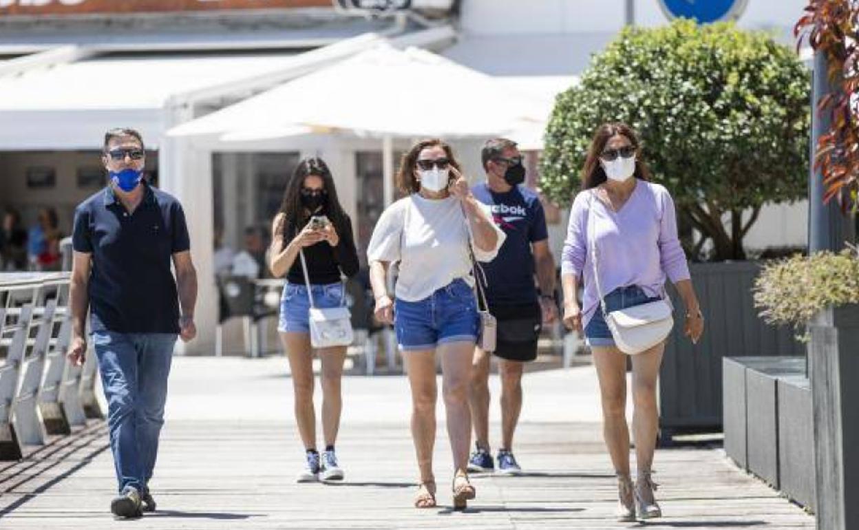 Varias personas, este viernes, en el paseo marítimo de la playa de Sanxenxo (Pontevedra).