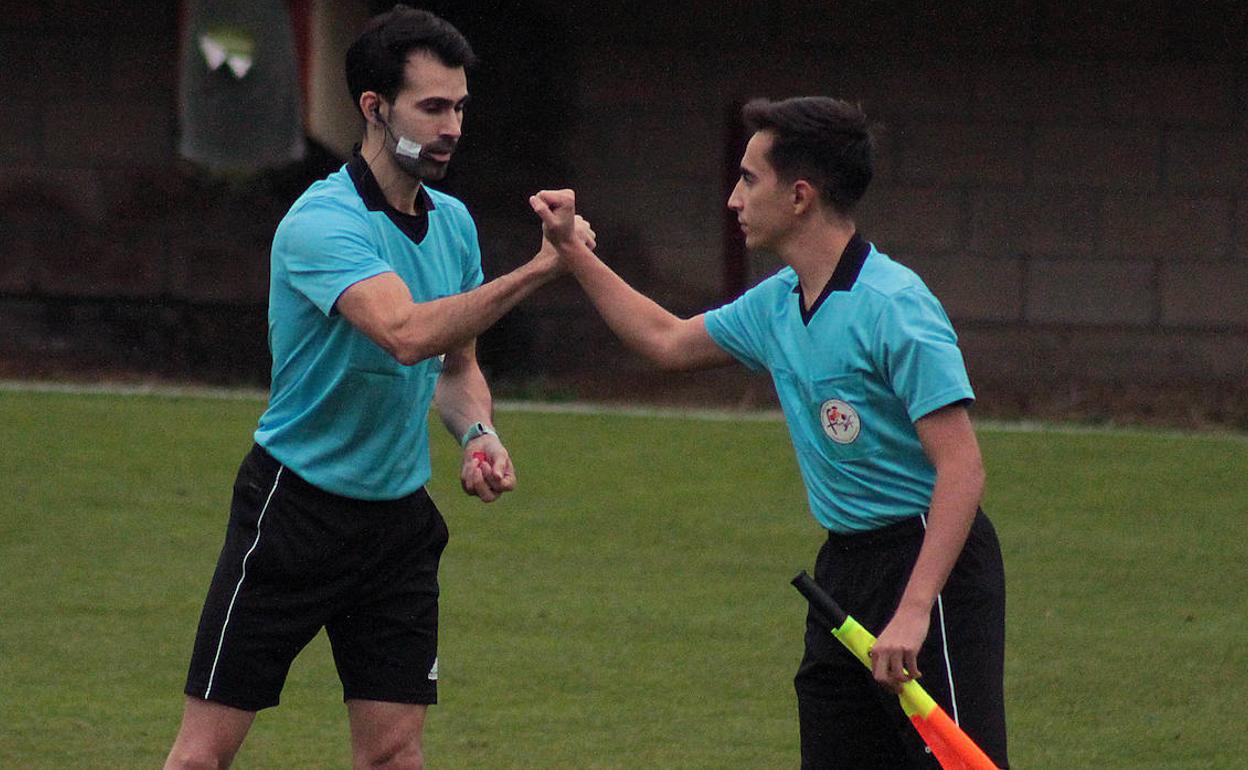 Imagen de dos árbitros en un partido.