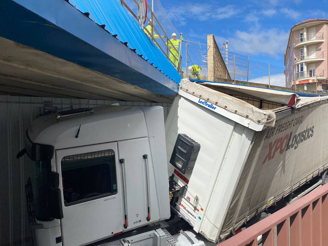 Fotos: Un camión queda atascado bajo las vías del tren