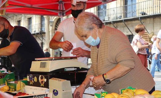 Visi coloca la fruta en el puesto del Mercado. 