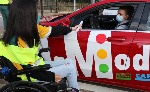 La joven con parálisis expone a un conductor su campaña de concienciación.