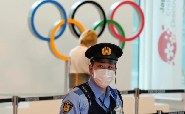 Un policía japonés en el aeropuerto de Tokio, ante los anillos olímpicos.