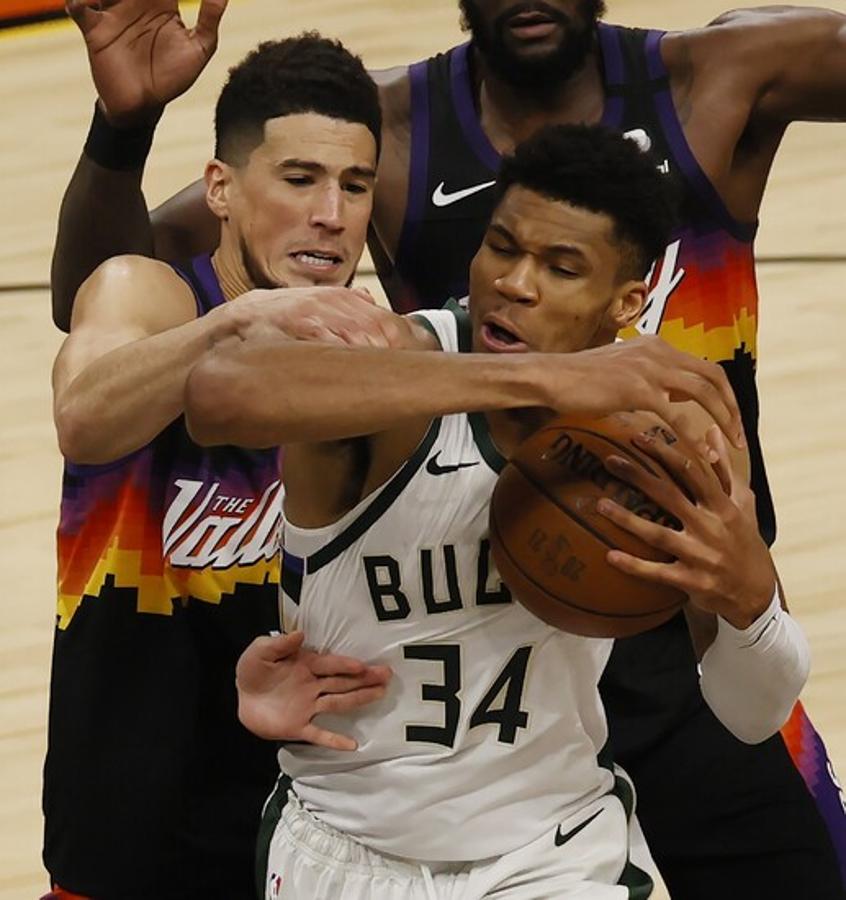 Giannis Antetokounmpo y Devin Booker luchan por un rebote en el segundo cuarto.