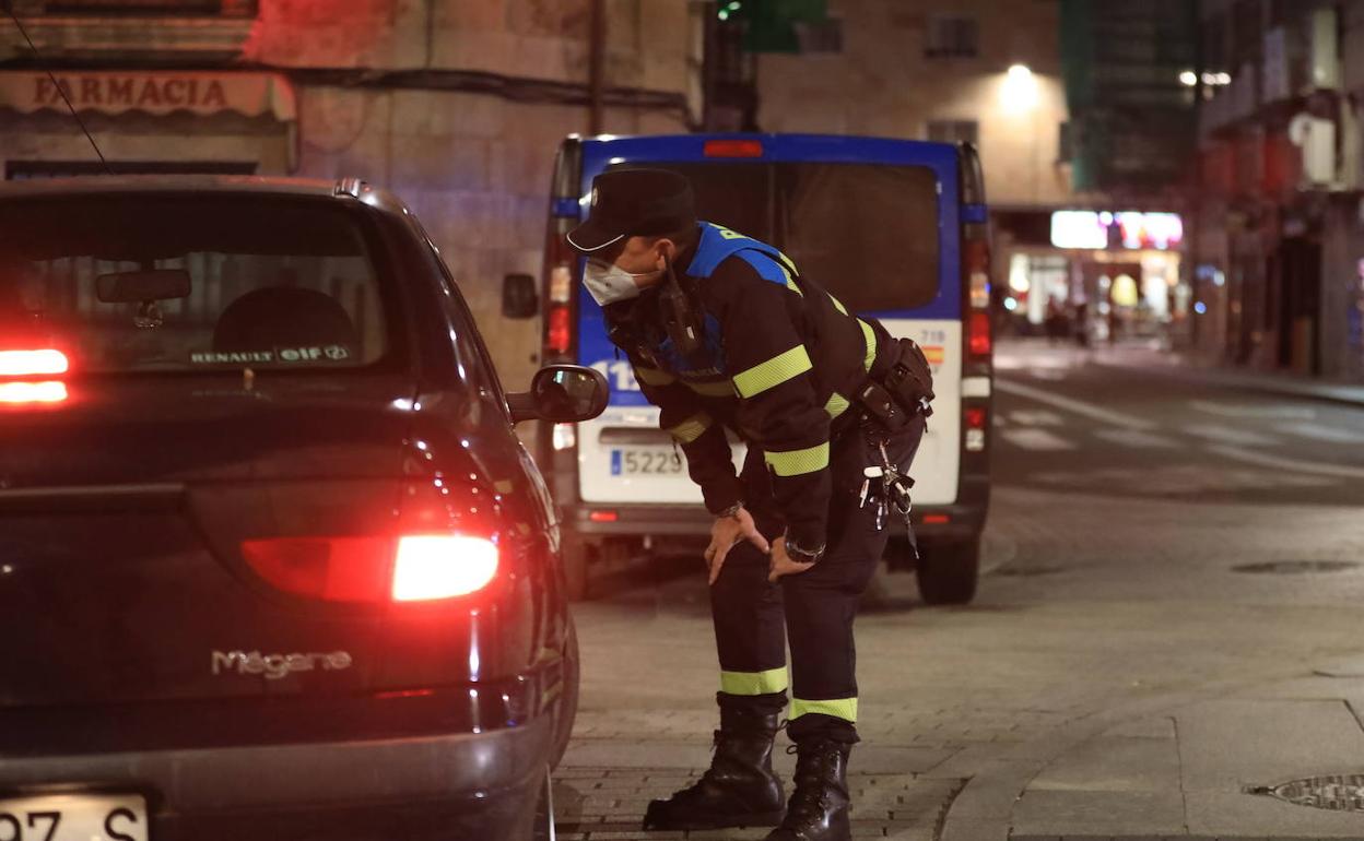 Un policía local de Salamanca controla salidas nocturnas durante el toque de queda..