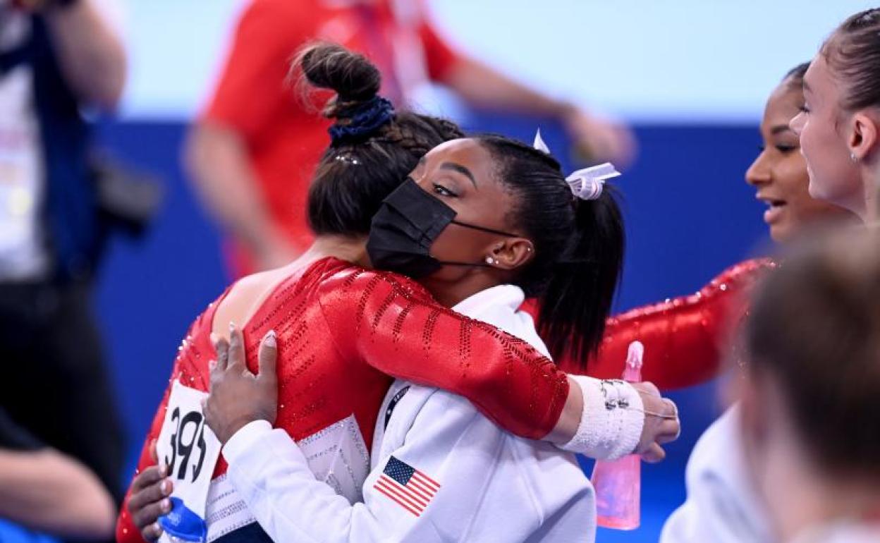 Simone Biles (d), abrazada por su compañera de equipo Sunisa Lee. 