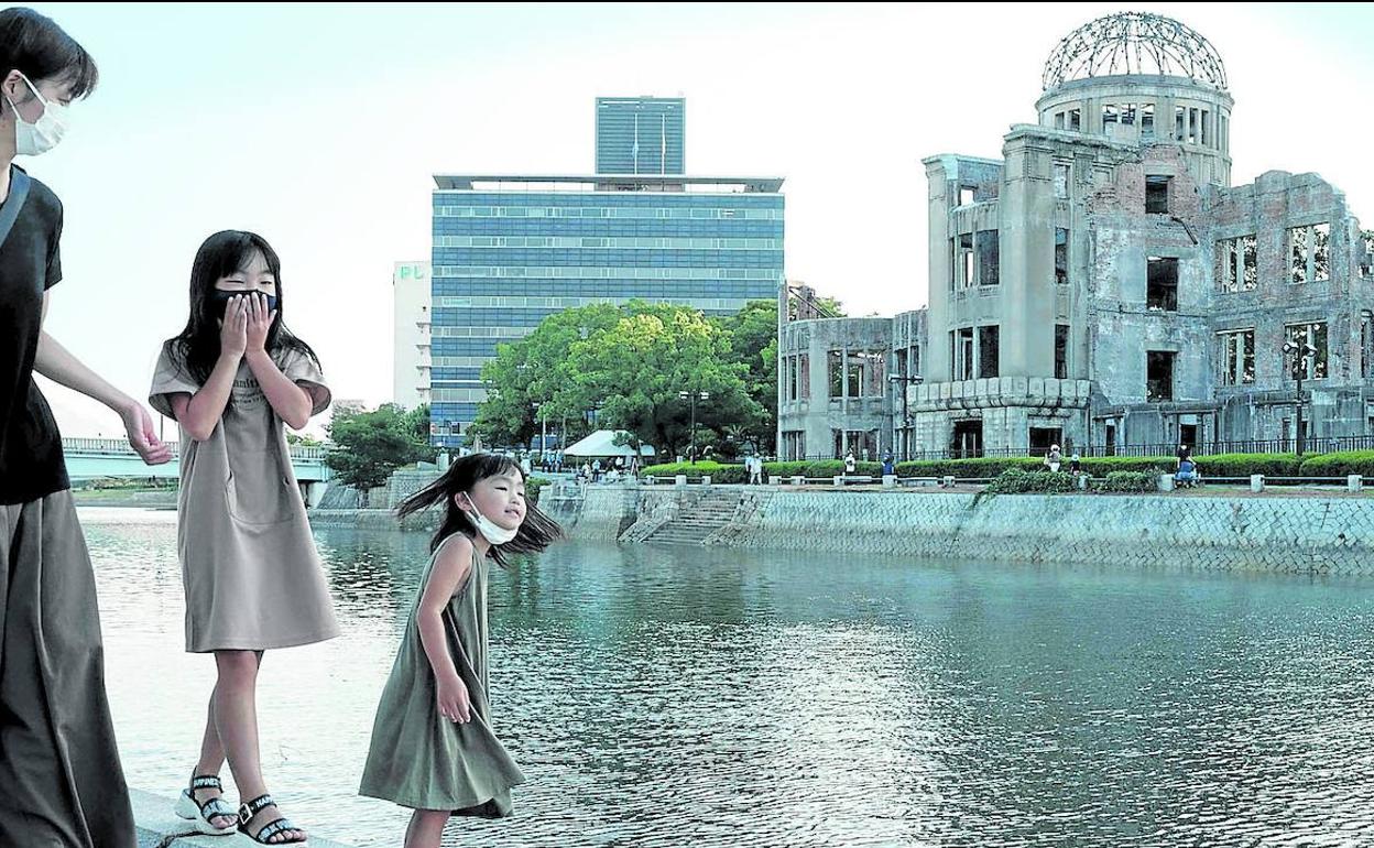 Una mujer y sus hijas pasean junto al monumento en recuerdo de las víctimas de la bomba nuclear en Hiroshima (Japón).