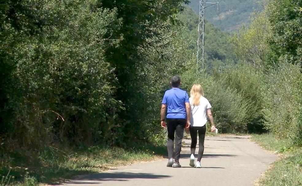 Dos veraneantes disfrutan de un paseo en plena naturaleza. 