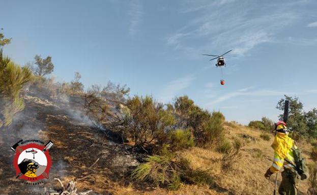 Imagen del helicóptero y la cuadrilla de tierra luchando contra el incendio.