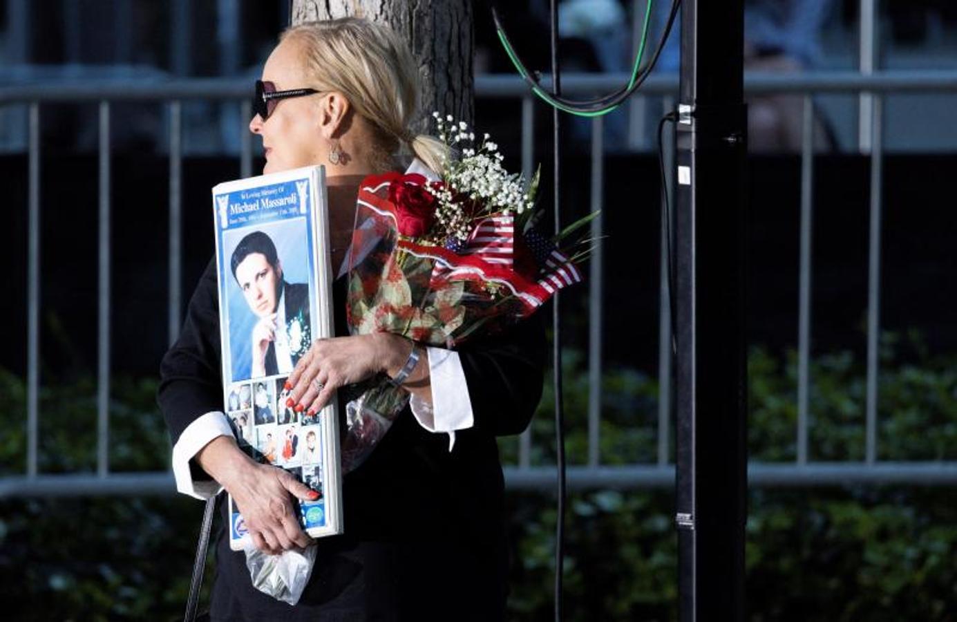 Una mujer, en la ceremonia en Nueva York con una imagen de un familiar fallecido.