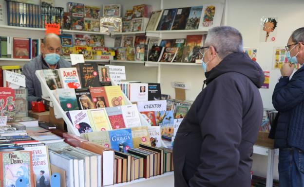 Imagen. Unos leoneses preguntan por un libro en uno de los stands. 