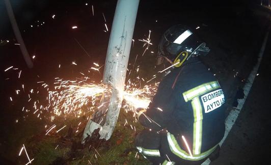 Un bombero retira la farola accidentada.