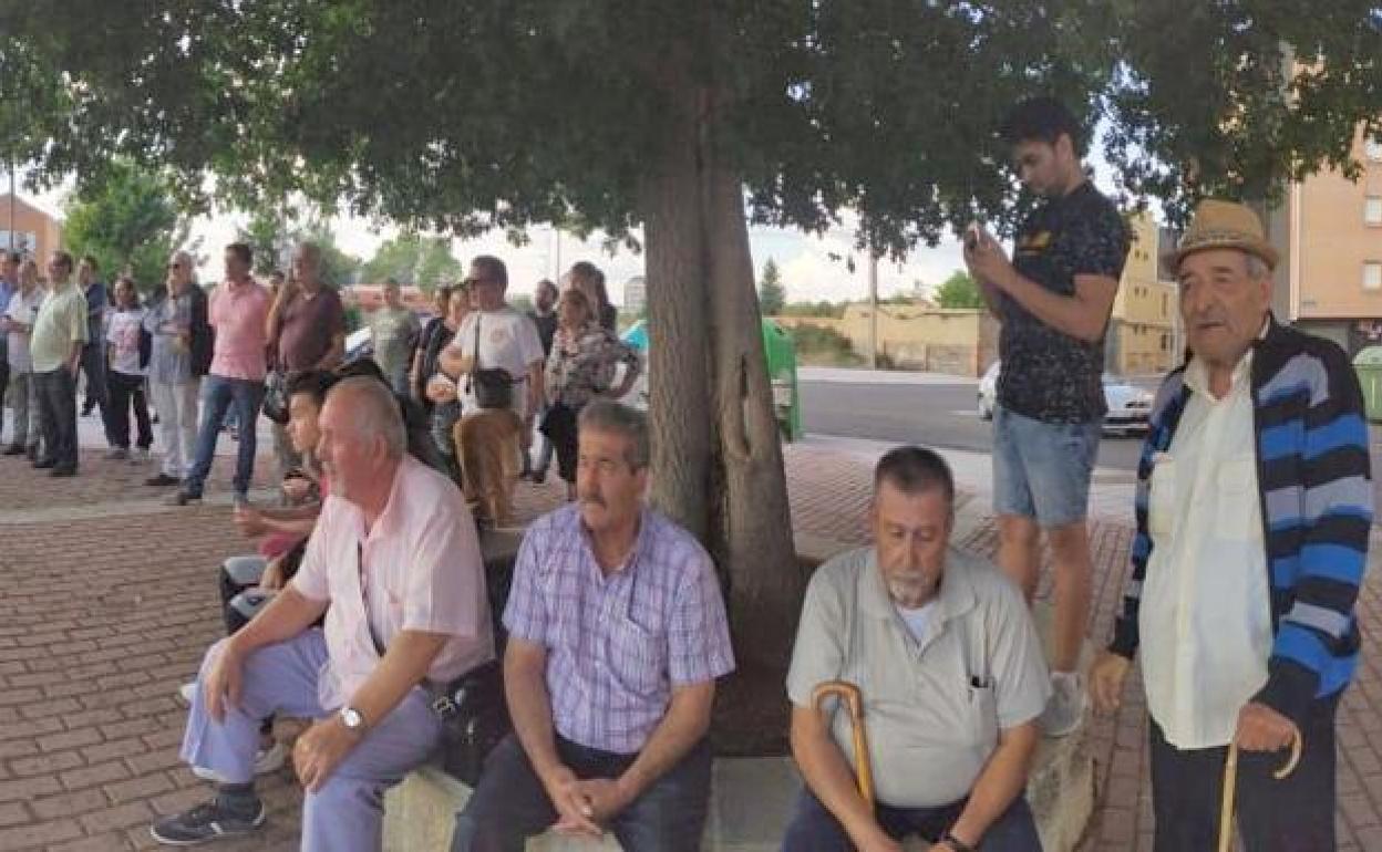 Varias personas del colectivo gitano observan un evento en una ciudad española.