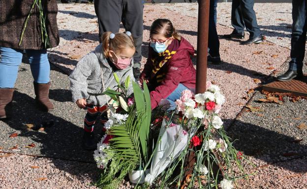 Galería. Dos niñas se acercan a adepositar sus flores.