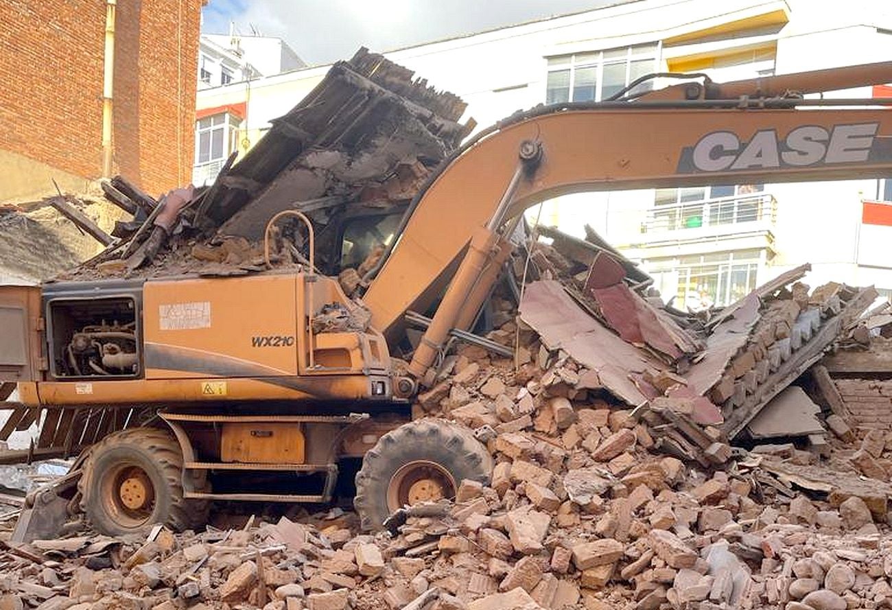 El derrumbe se ha producido cuando la máquina procedía al derribo de un inmueble en la calle Alfonso el Justiciero de León capital | Efectivos de Bomberos han acudido al lugar para auxiliar al operario que, finalmente, ha podido abandonar el vehículo sin dificultad. 