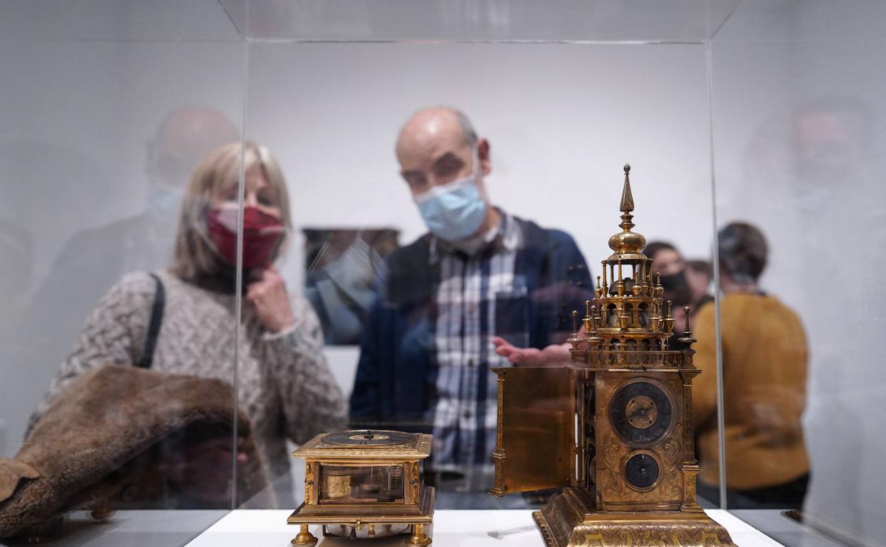 Una pareja de visitantes observa un par de relojes expuestos en el MNAD. 