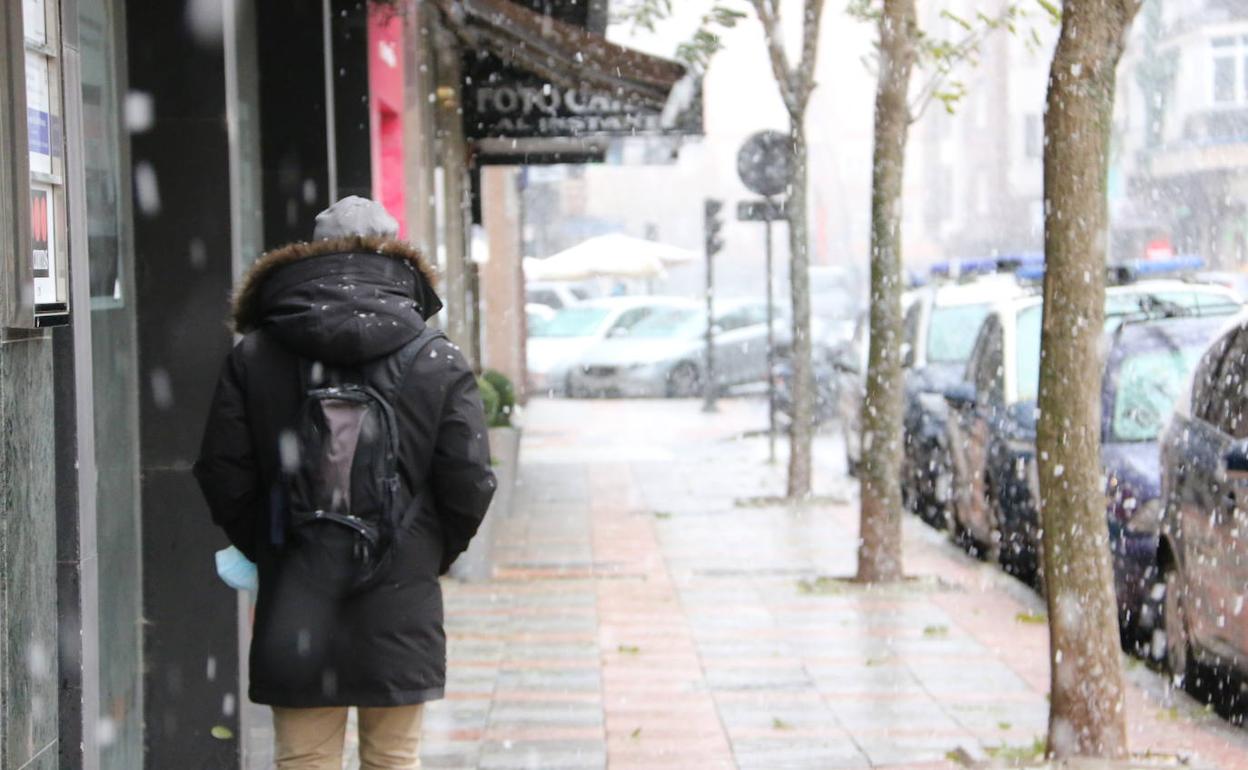 Un joven pasea bajo la nevada de este sábado en la capital leonesa. 