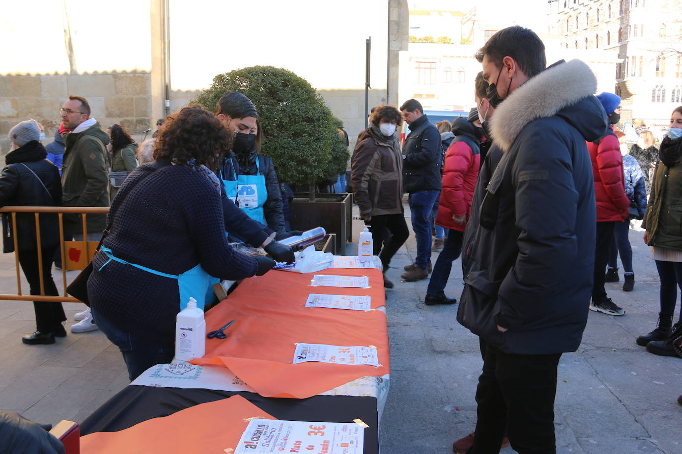 Centenares de personas participan en el corte de platos de jamón por una acción benéfica.