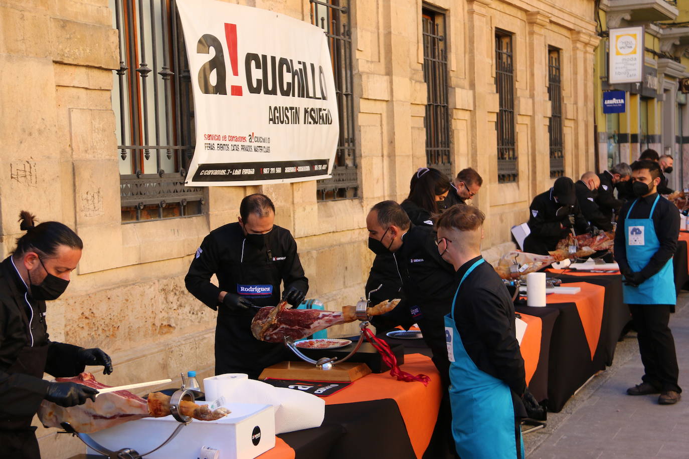 Centenares de personas participan en el corte de platos de jamón por una acción benéfica.