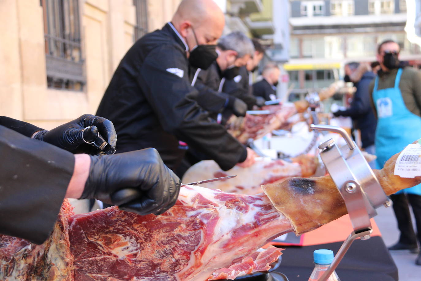 Centenares de personas participan en el corte de platos de jamón por una acción benéfica.