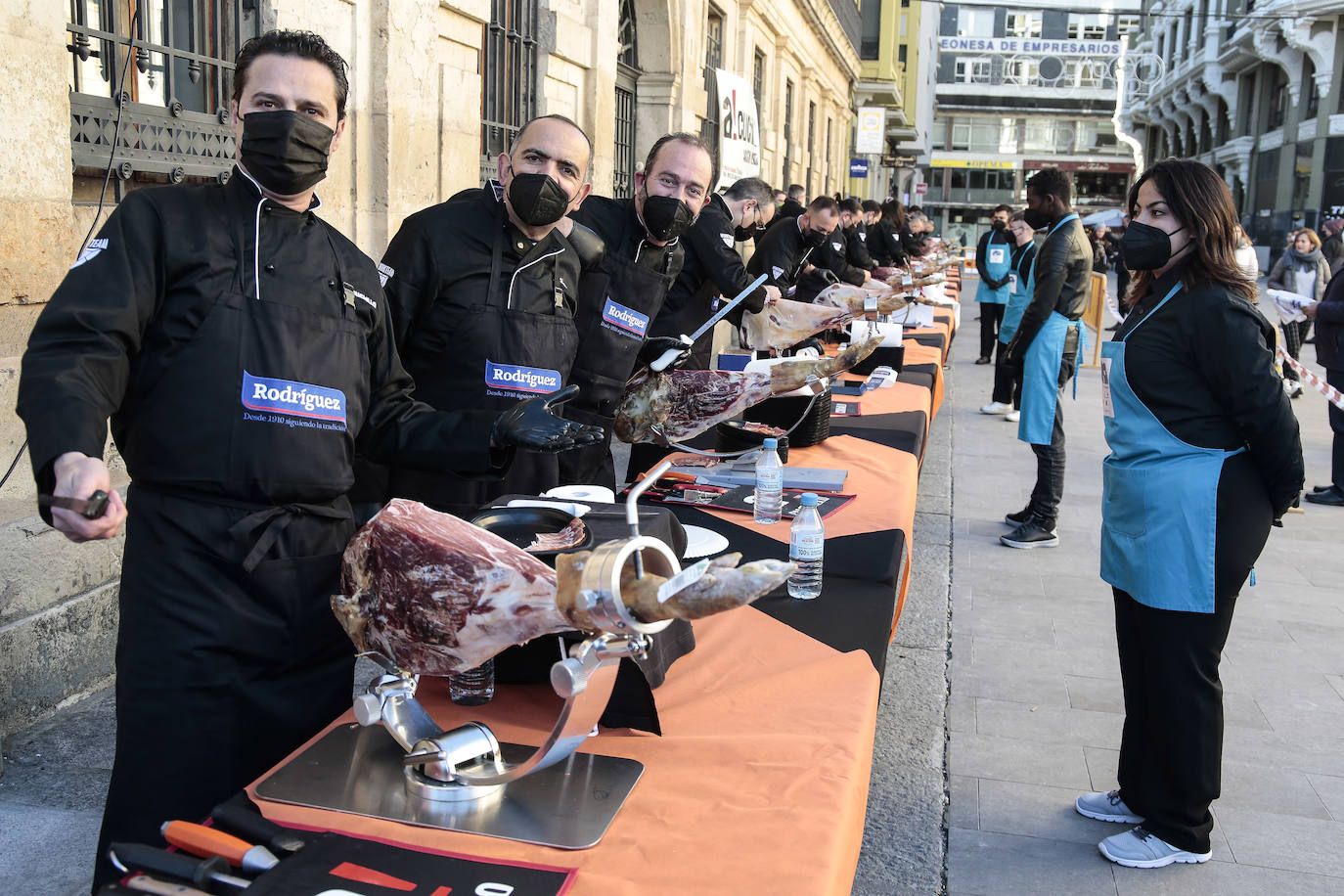 Centenares de personas participan en el corte de platos de jamón por una acción benéfica.