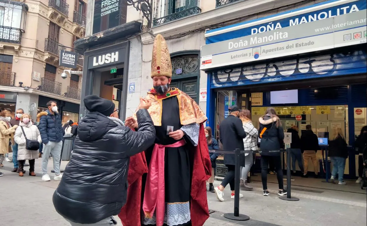 El obispo de la lotería, el leonés Juan, ha acudido este domingo a las puertas de Doña Manolita para bendecir décimos de la lotería de Navidad.