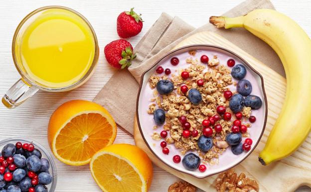 Imagen de un desayuno completo con fruta, lácteos y cereales. 