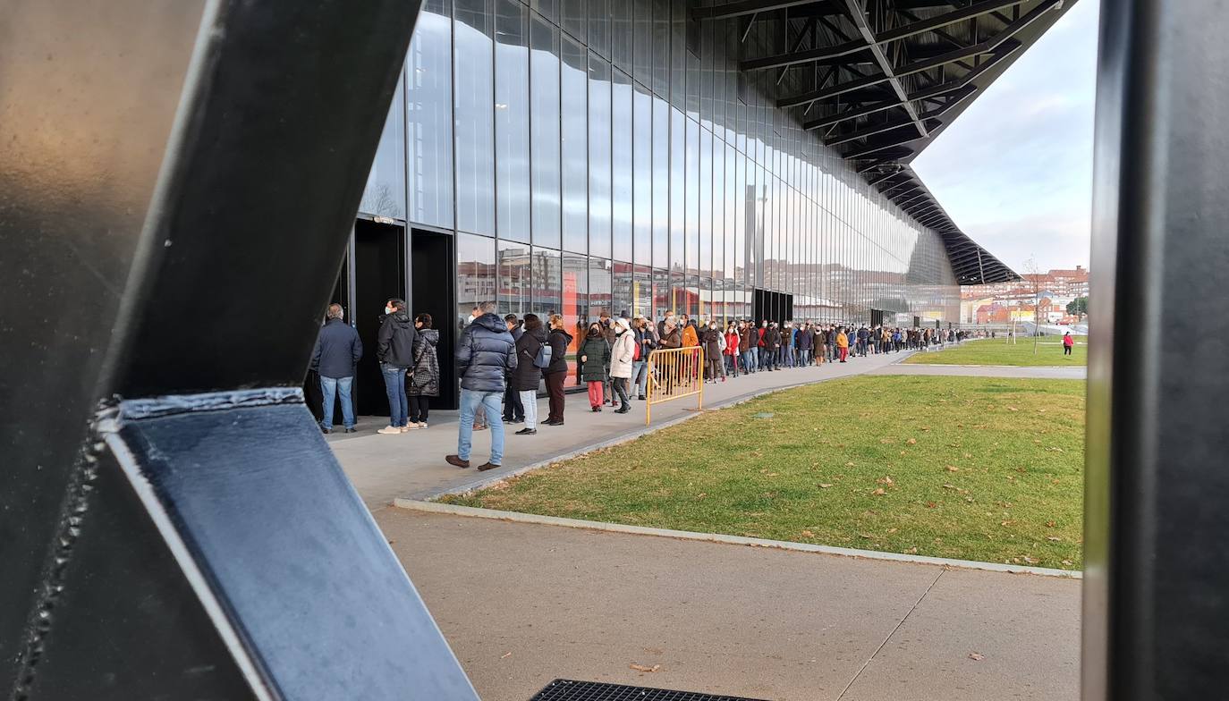 Una hora antes de la apertura de puertas en el 'vacunódromo' del Palacio de Exposiciones los leoneses 'de los 60' ya hacen cola para inocularse la tercera dosis | La cola, que ha llegado a alcanzar el kilómetro durante este martes, evidencia la alta respuesta al llamamiento. 