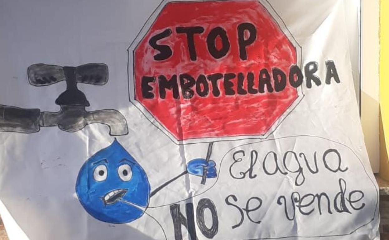 Uno de los carteles repartidos por los pueblos implicados contra la embotelladora. 