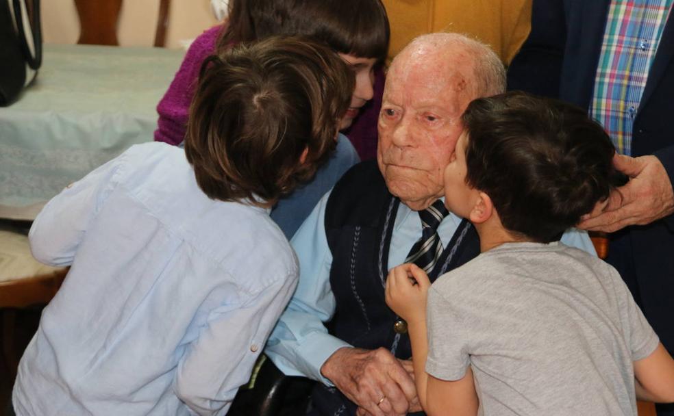 Saturnino de la Fuente sopla las velas en su 111 cumpleaños, rodeado de su familia. 