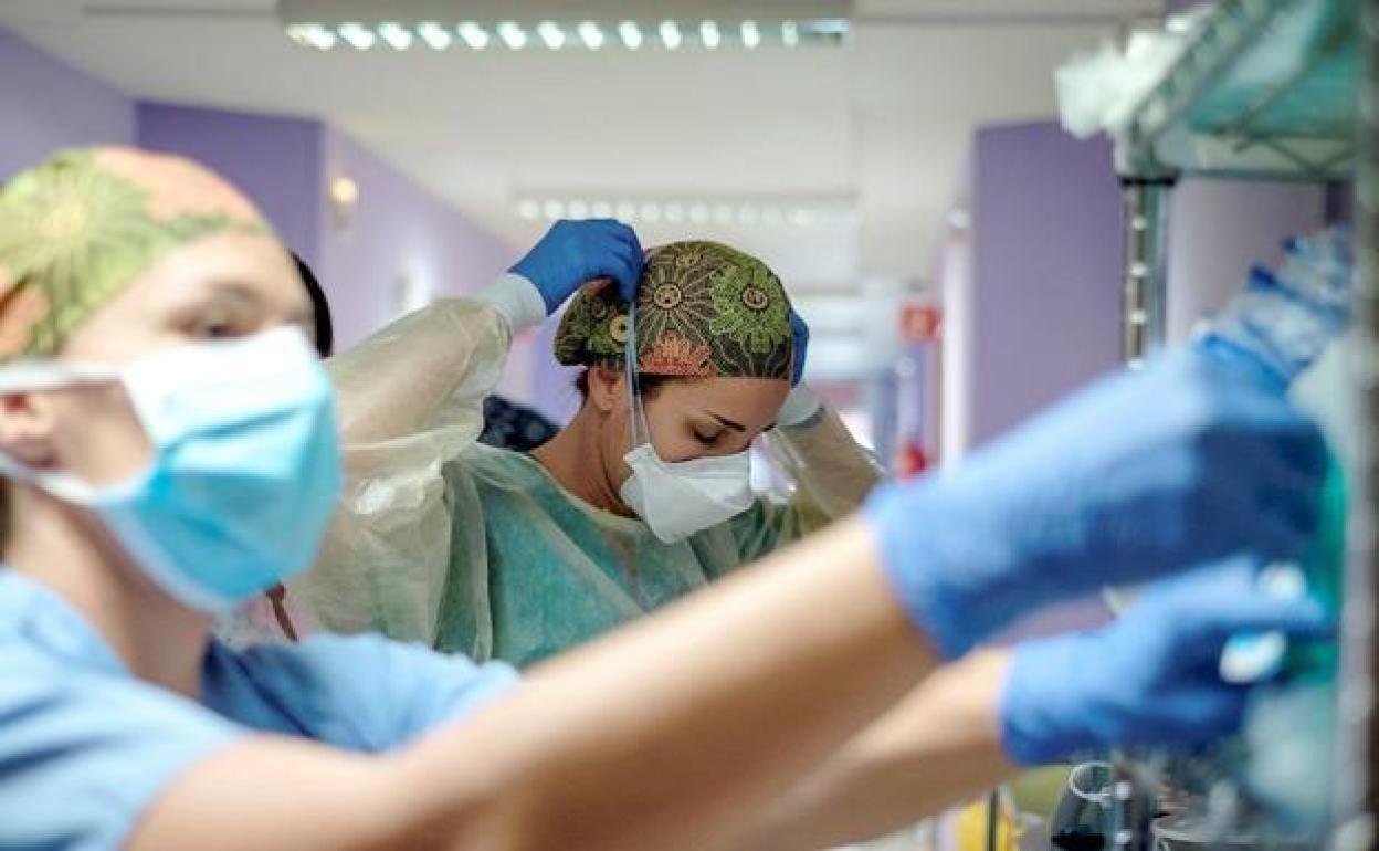 Dos profesionales sanitarios en el pasillo d eun hospital. 