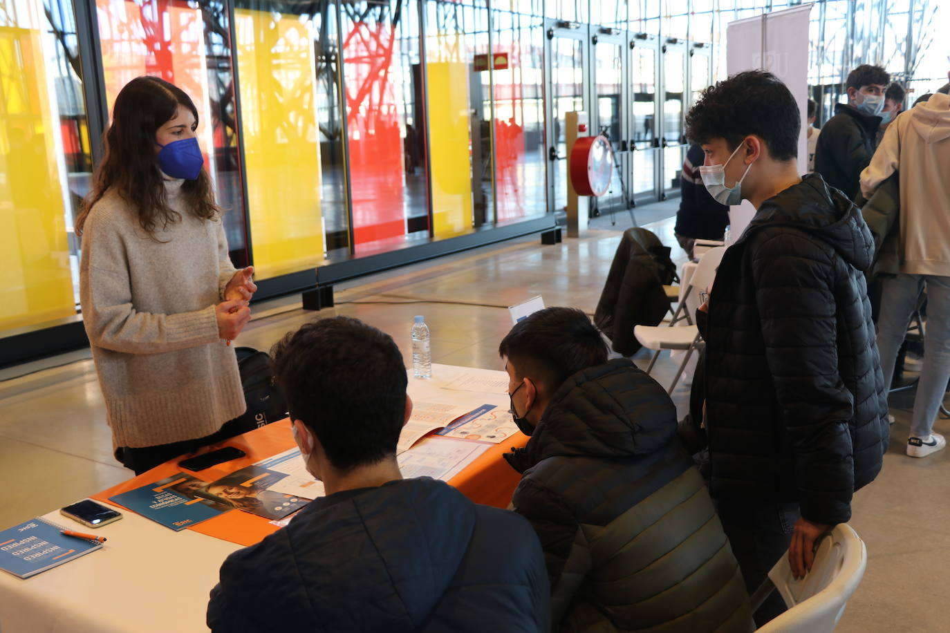 Una orientadora de una universidad atiende a tres alumnos en Unitour, en el Palacio de Exposiciones.