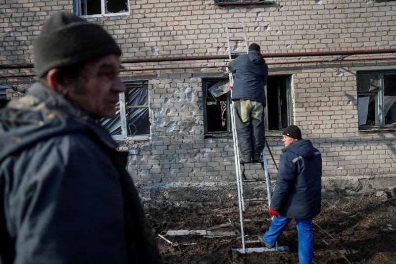 Trabajadores municipales inspeccionan otra casa afectada por las bombas. 