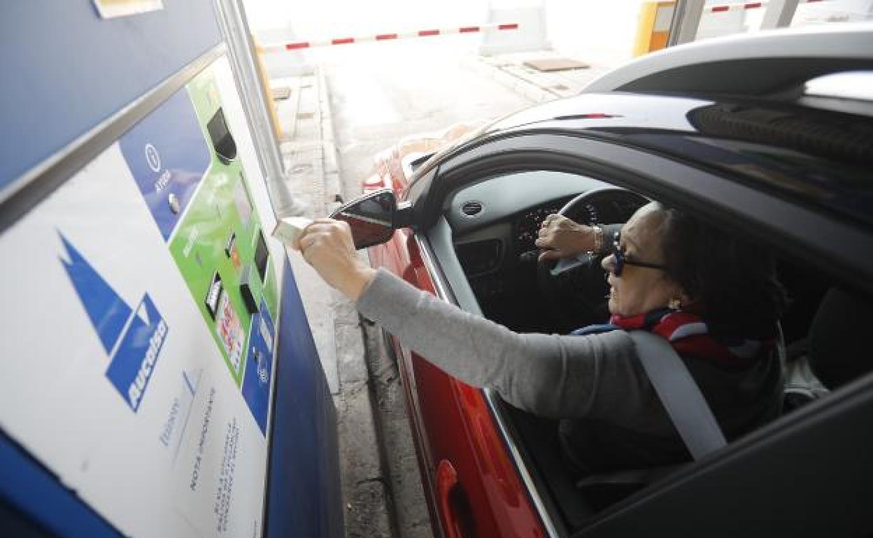 Una usuaria usa una tarjeta para abonar el peaje en una de las cabinas de pago en La Magdalena, en la autopista del Huerna.