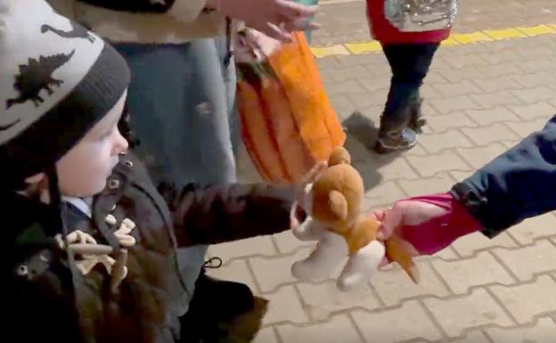 Un niño recibe un muñeco a la llegada a la estación. 