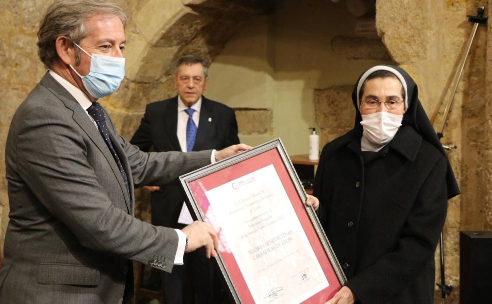 La abadesa de Madres Benedictinas, sor Ernestina, recibe de manos del presidente de la Cámara de Comercio de León, Javier Vega, el reconocimiento como Personaje Singular de la Semana Santa 2022.