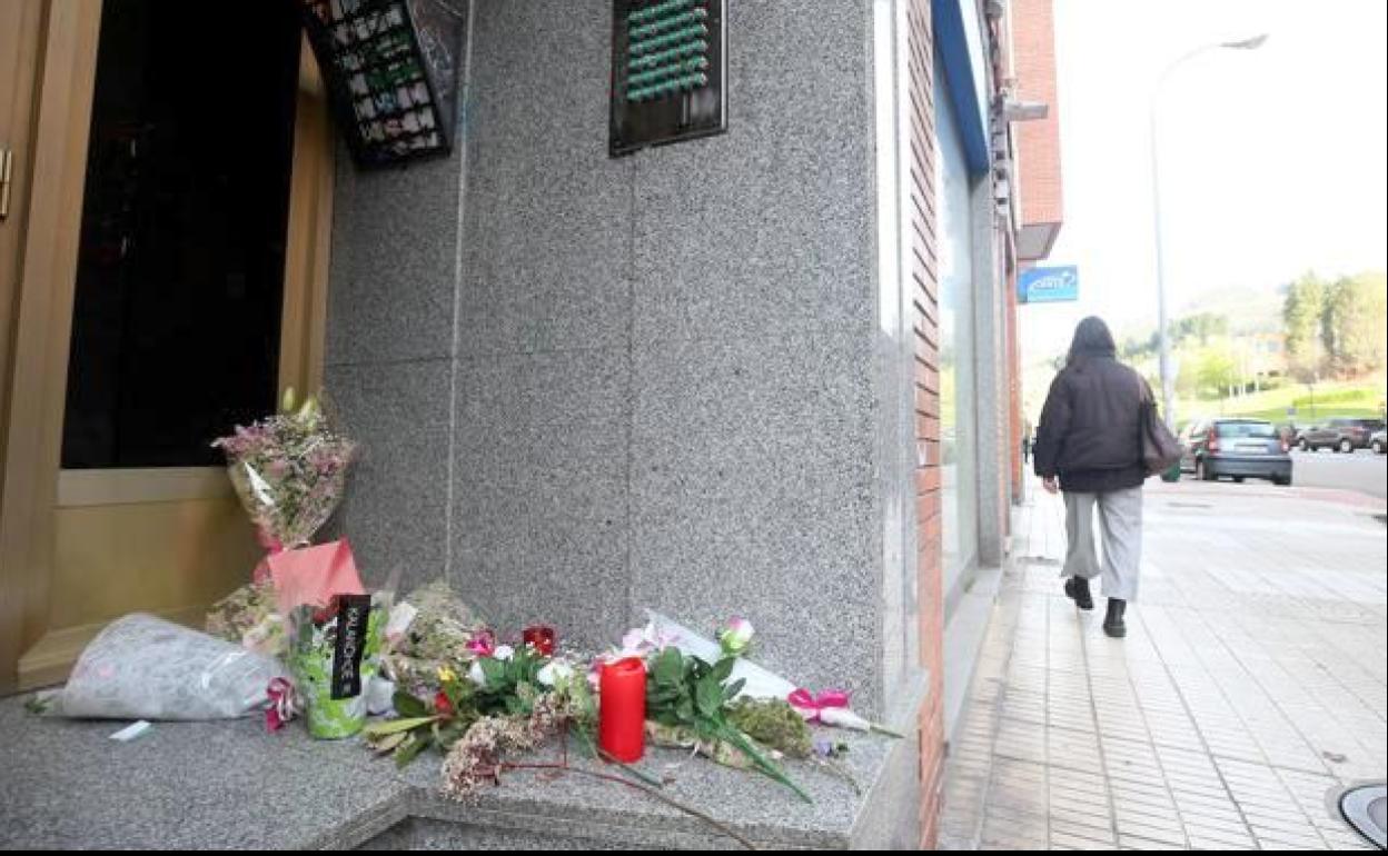 Flores en el portal del edificio donde fue asesinada la joven Erika Yunga. 