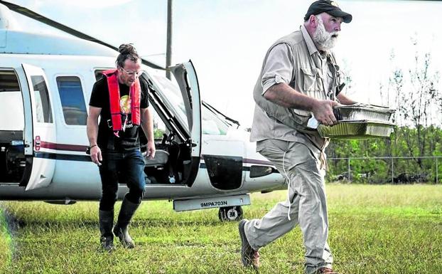 Imagen principal - 1. El chef desciende de un helicóptero con bandejas de comida en el transcurso de una emergencia humanitaria, en una escena del premiado documental 'We feed people'. | 2. Profeta en su tierra. José Andrés, durante la ceremonia del premio princesa de Asturias de la Concordia. | 3. Portada de la revista Time tras ser propuesto al Nobel. 