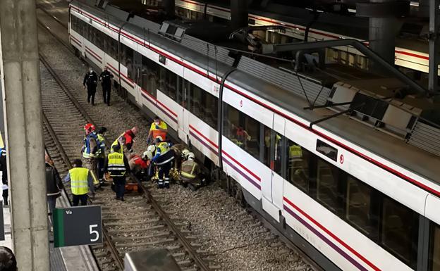 Instante en el que los equipos de emergencia tratan de sacar al hombre herido de las vías del tren.