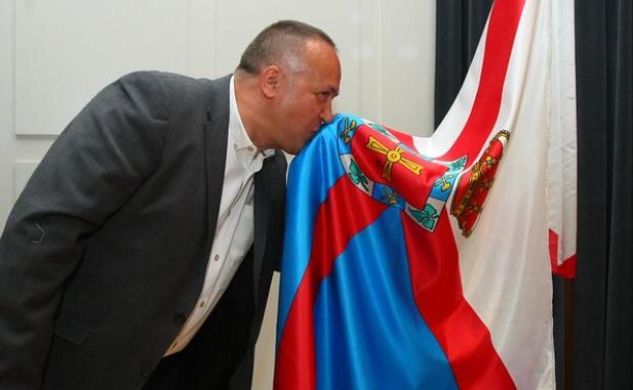 El presidente del Consejo Comarcal, Gerardo Álvarez Courel, besa la bandera de El Bierzo durante su toma de posesión.