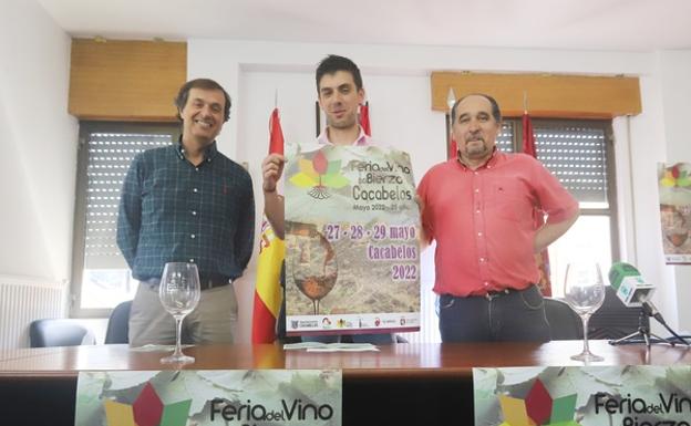 El alcalde de Cacabelos (C), el concejal de Ferias y el presidente de la DO Bierzo, muestran el cartel del certamen vinícola.