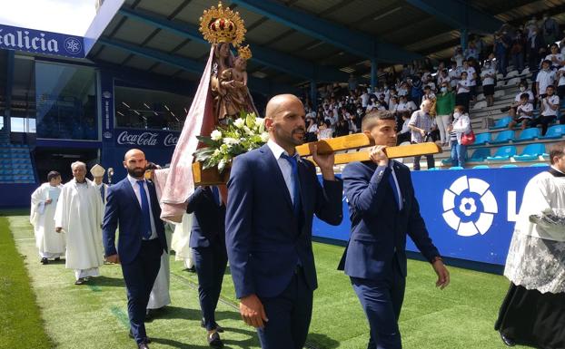 El capitán de la Ponferradina, Yuri de Suza (I), porta a hombros la imagen de la Virgen de la Encina junto a otros miembros del equipo en el campo del Toralín en la celebración del Centenario del club.