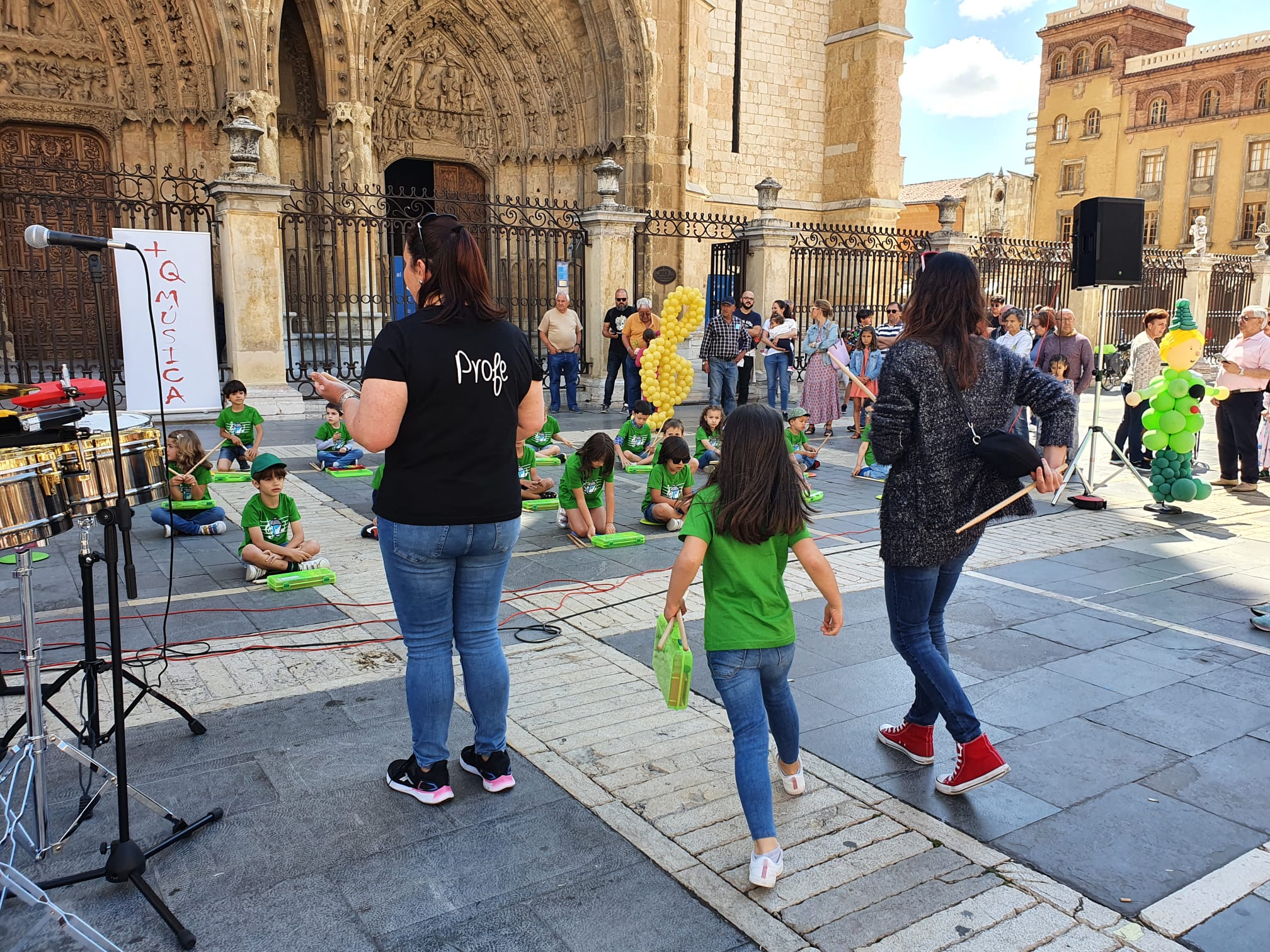 Música solidaria a los pies de la Catedral. Los pequeños alumnos de '+QMÚSICA' han sacado sus instrumentos en la plza de la Regla para mostrar las acciones sociales que realiza la Sociedad de San Vicente de Paúl.