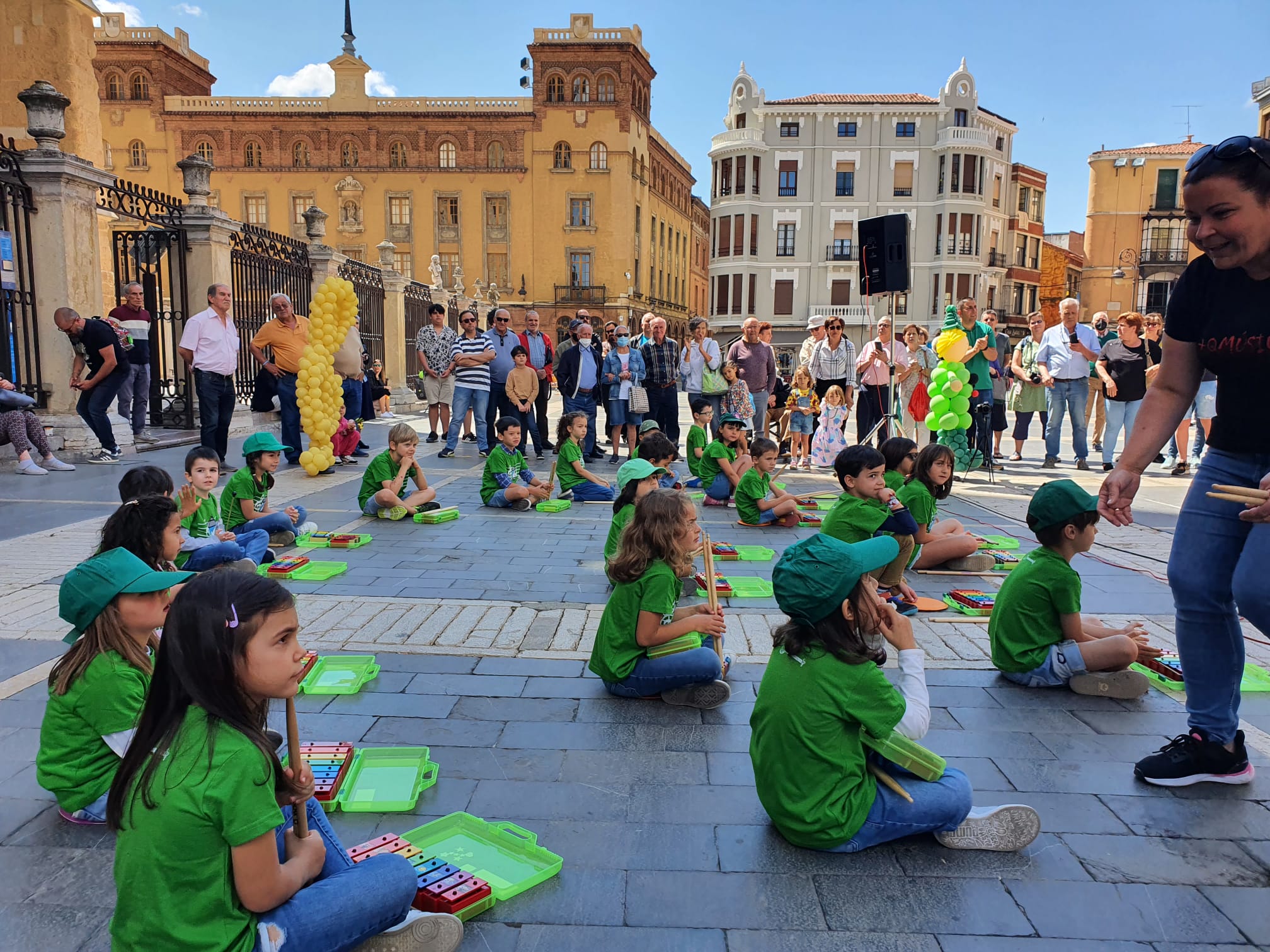 Música solidaria a los pies de la Catedral. Los pequeños alumnos de '+QMÚSICA' han sacado sus instrumentos en la plza de la Regla para mostrar las acciones sociales que realiza la Sociedad de San Vicente de Paúl.