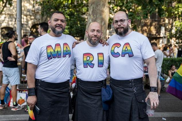Tres participantes posan durante la manifestación con las sílabas de la palabra 'Marica' en sus camisetas. 