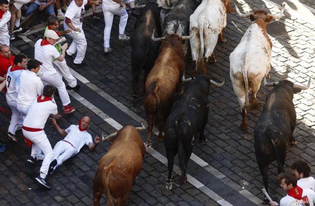 Un mozo cae al suelo en el transcurso del encierro. 