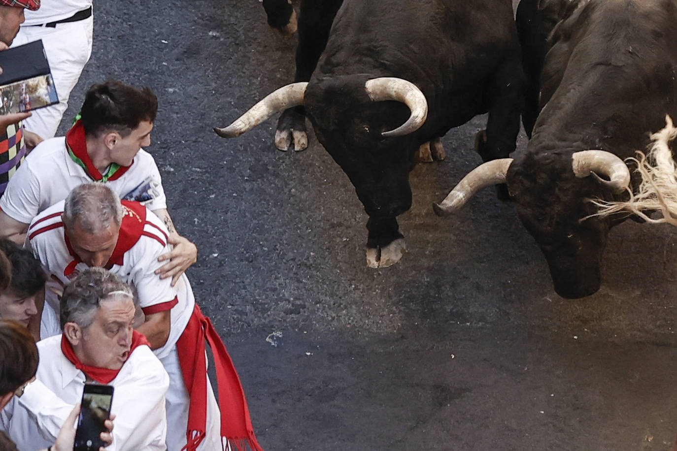 Los toros de la ganadería pacense de Jandilla enfilan la Cuesta de Santo Domingo en los primeros metros del sexto encierro.