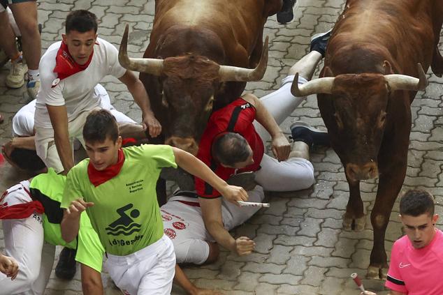 Los mozos, durante el octavo y último encierro de los Sanfermines con toros de la ganadería de Miura en el tramo final de entrada a la Plaza de Toros de Pamplona.