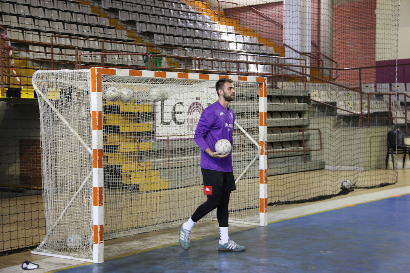 La plantilla del Ademar realiza flexiones en medio de la cancha del Palacio de los Deportes. 